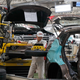 In this Feb. 19, 2017 file photo, a worker prepares to put a spare tire into a Haval SUV H2 model in the Great Wall Motors assembly plant in Baoding in north China’s Hebei province. Image credit: Andy Wong/AP Images